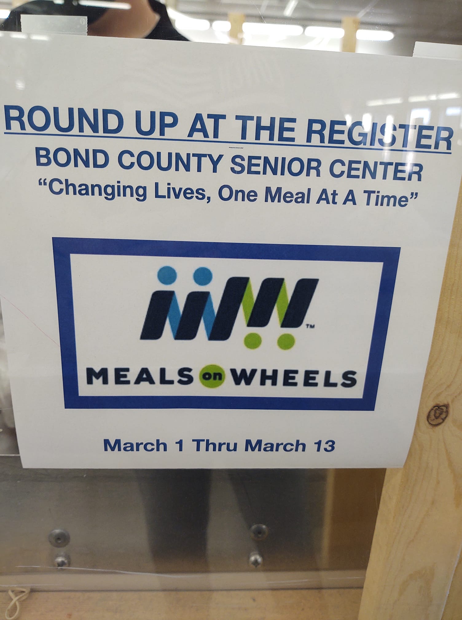 blue text and Meals on Wheels program logo inviting shoppers to round up at the register.